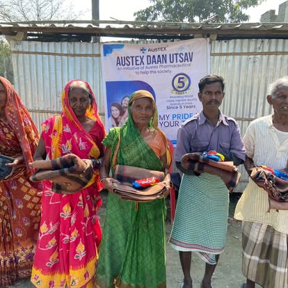 Community members holding blankets received at the Austex Daan Utsav distribution